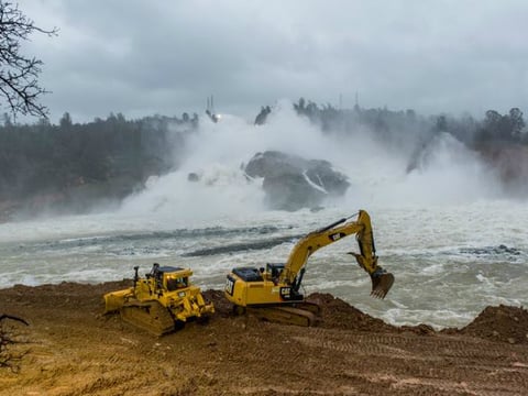 Heavy equipment operators dig access points to the river below Oroville Dam to allow access to remove the sediment at the base of the spillway on February 17, 2017.